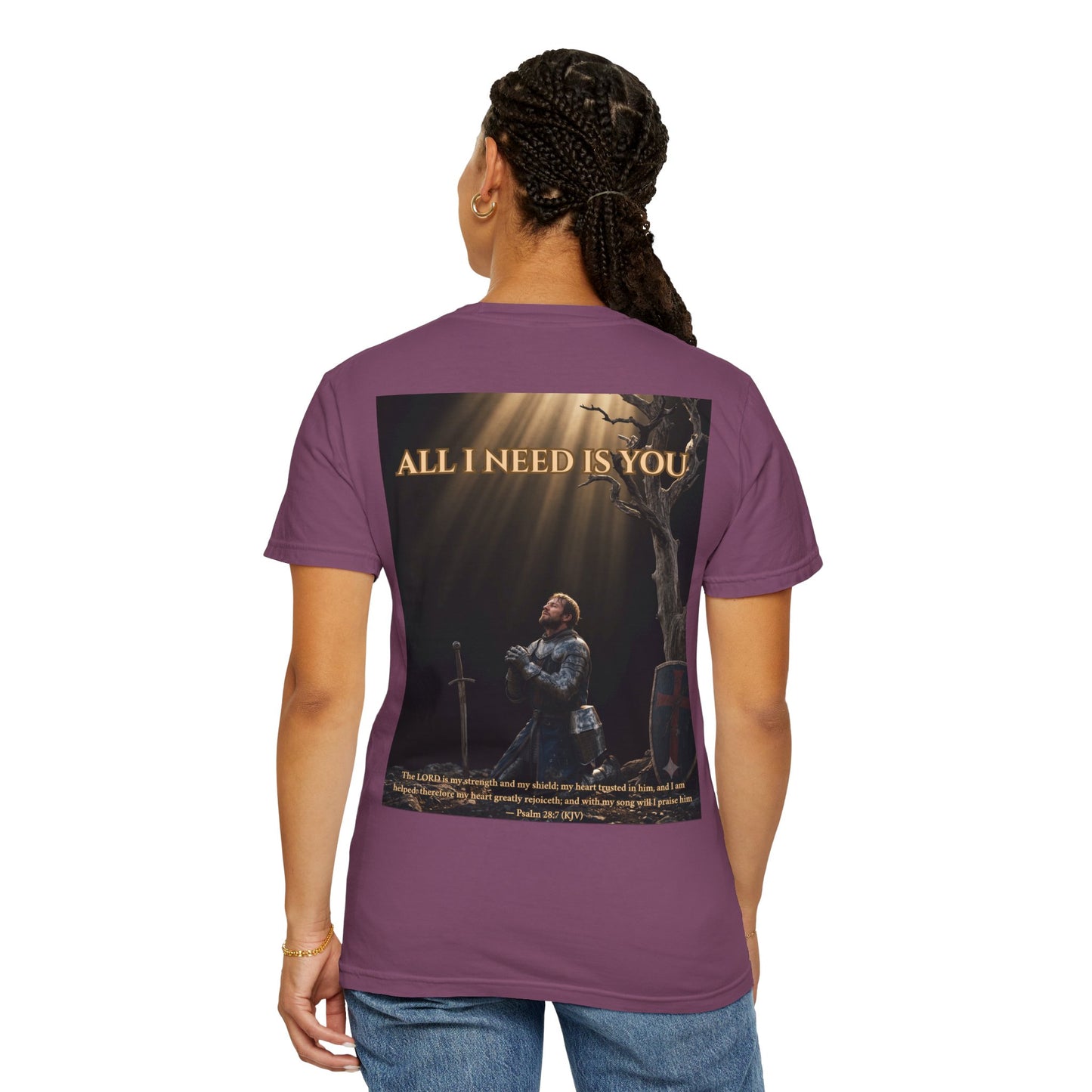 A woman wearing ALL I NEED IS YOU faith tee in Berry – back view showing a sword of prayer driven into stone and Psalm 28:7 (KJV)